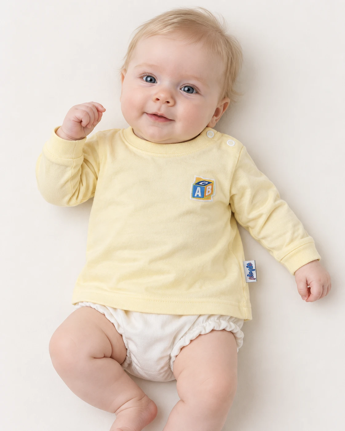 Bebê usando a camiseta amarela com bordado ABC