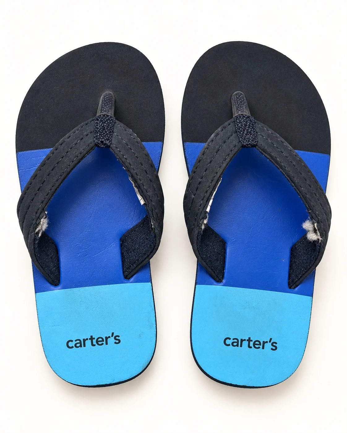 Chinelos vistos de cima, com a marca Carter's na palmilha